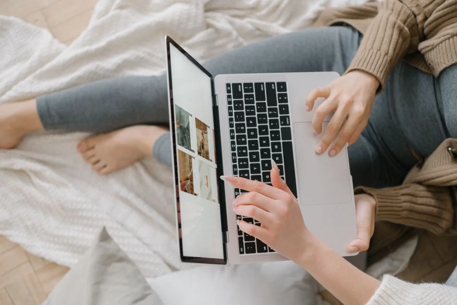 Person analyzes stock data with a smartphone and laptop, indoors.